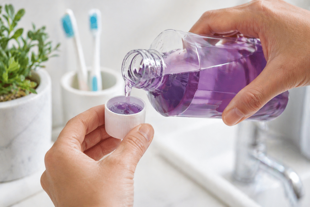 mondwater uit een fles in de dop gieten