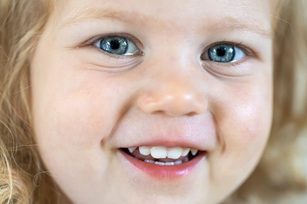 Kind met zichtbaar melkgebit en eerste tanden, een moment waarop ouders zich afvragen vanaf welke leeftijd tandarts nodig is