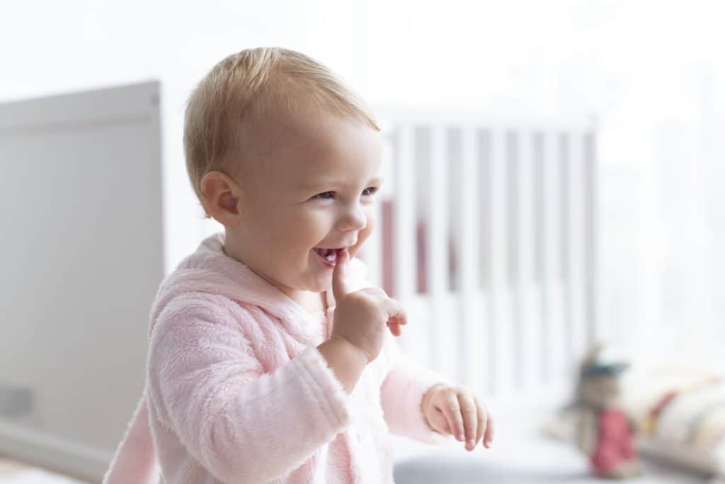 Baby met vinger in de mond tijdens het doorkomen van tandjes, een fase die hoort bij de doorkomen tandjes volgorde bij baby’s.